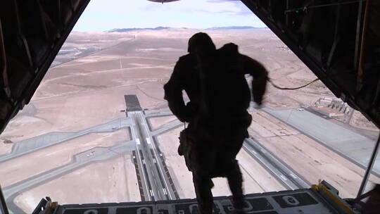 伞兵从机场上空的飞机上跳下