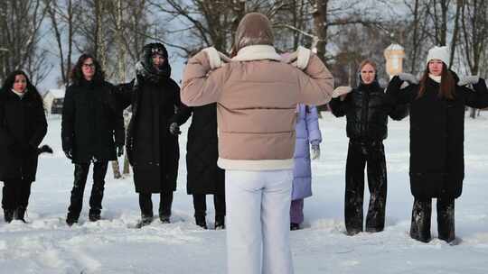 快乐的年轻女学生享受冬季照片拍摄嬉戏踢雪