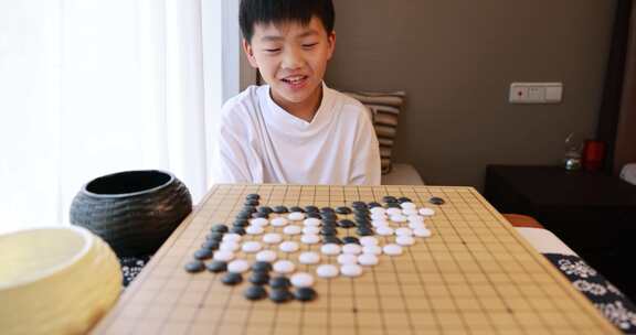 可爱的男孩在窗边下围棋