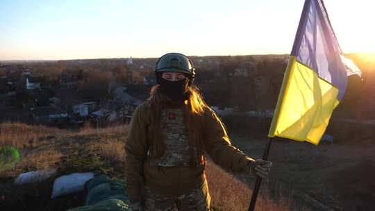 身穿军装的妇女站在日落前，举起乌克兰女军