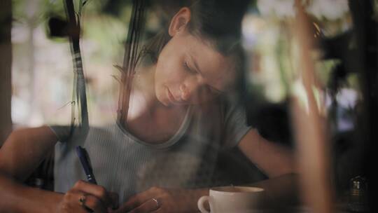 女人坐在窗边写作视频素材模板下载