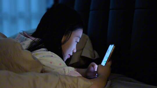 女子夜晚刷手机疲惫揉眼