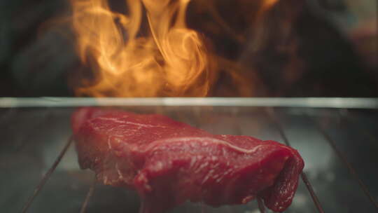 不锈钢烤肉仓库的烤肉牛排，深色背景下着火视频素材模板下载