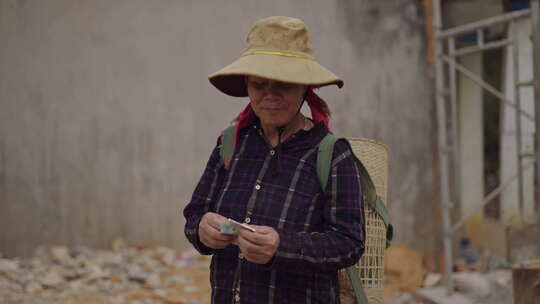 成熟越南女人与一个大帽子在她的头数的钱她