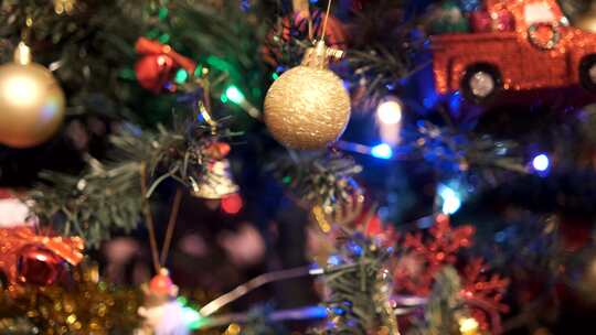 女人在圣诞树上挂上金色装饰球视频素材模板下载
