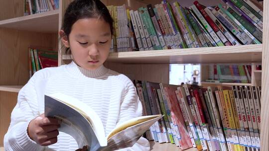 4K升格实拍坐在图书馆书架旁看书的女孩