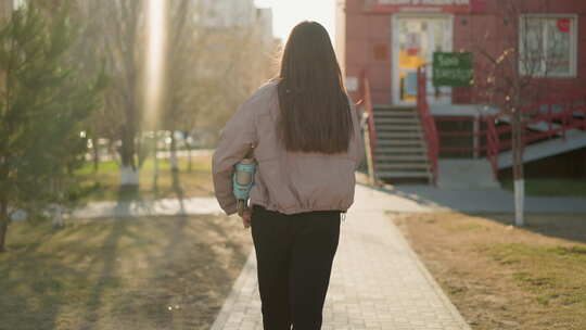 女孩在阳光明媚的城市路径桃子夹克下午场景