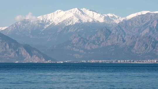 特写被大雪覆盖的阿尔卑斯山脉与山脚湖泊视频素材模板下载