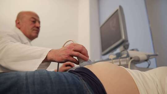 男医生在医院为孕妇做超声检查妊娠