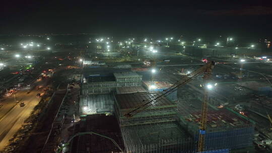 建筑工地夜景。巨大建筑上方的无人驾驶飞机