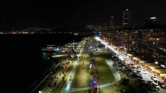 伊兹密尔市的夜景，海边的建筑和海滩上的人