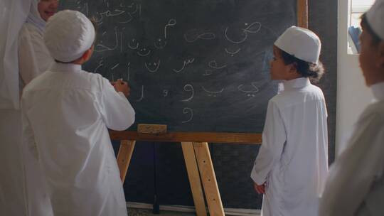 清真寺教师教儿童在黑板上画画