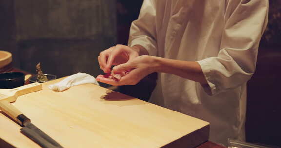 寿司厨师手，鱼和餐厅在餐桌上准备餐点，晚