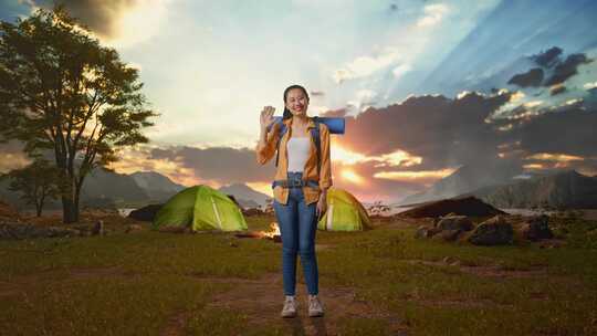 全身体的亚洲女性徒步旅行者挥手而帐篷营地