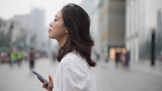 成都街头白领女青年看手机走在街上