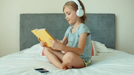 女孩在耳机里听音乐看书