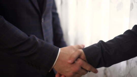 西装革履的两位男性握手拥抱视频素材模板下载