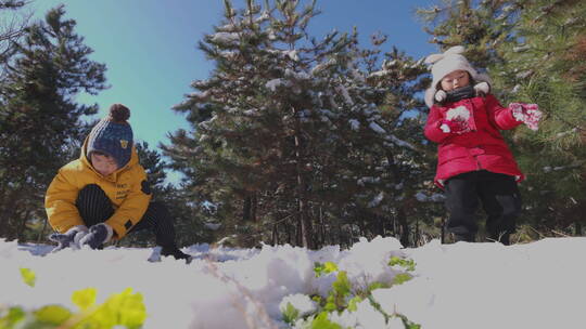 快乐儿童在雪地里打雪仗