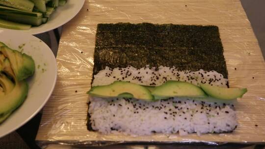 竹垫上正在制作黄瓜和海鲜卷的寿司