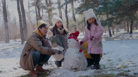 快乐家庭在雪地里堆雪人