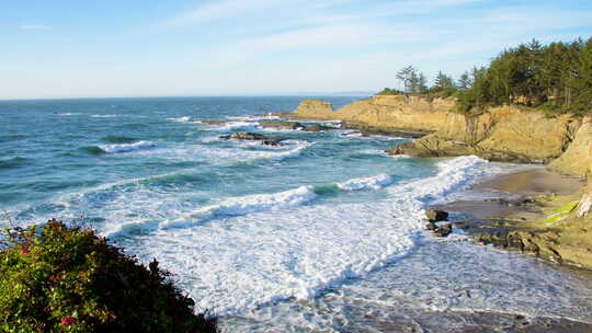 温柔的海浪在靠近库斯湾的俄勒冈州南部海岸上岸。拍摄于白天。