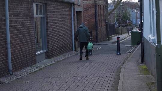 老人走在巷子里的手持宽镜头