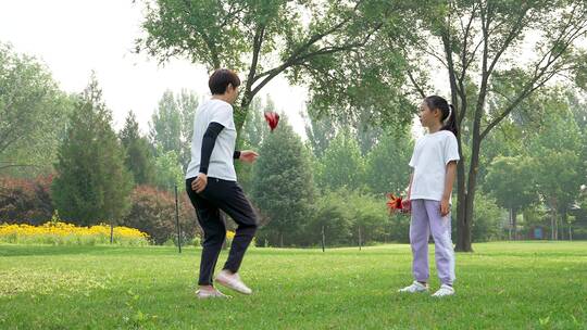 夏天在公园一起玩踢毽子游戏的中国母女