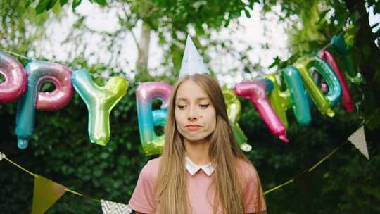 一个戴着派对帽的悲伤女人独自站在节日生日