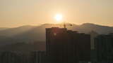 城市摩天大楼建筑工地塔式起重机上的日出。延时高清在线视频素材下载