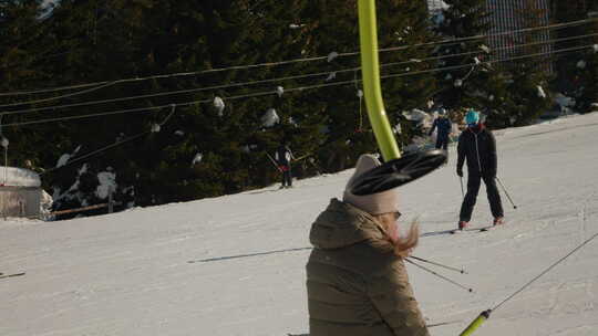 女孩紧紧握着滑雪杆滑下滑雪道。