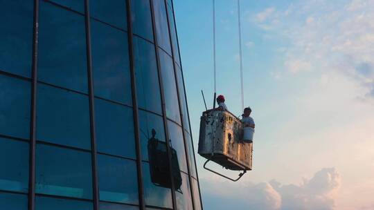 蜘蛛人工人在摩天大楼悬挂上升