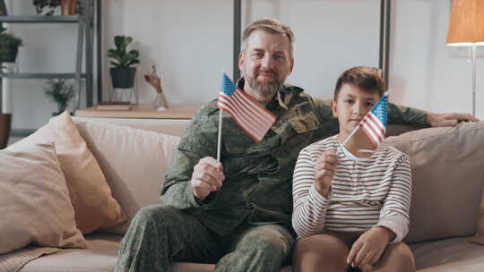 陆军士兵和他的儿子挥舞着美国国旗视频素材模板下载