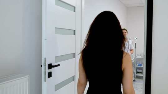 穿着黑色紧身衣的苗条女人病人走进美容柜女视频素材模板下载
