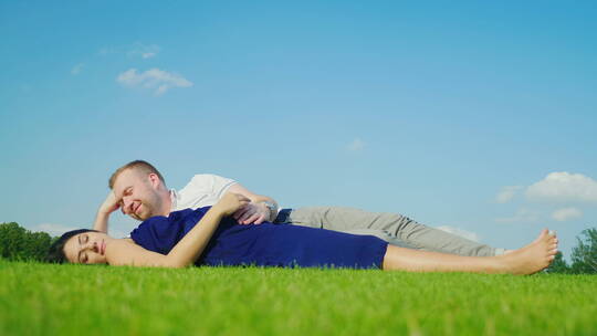丈夫与怀孕的妻子躺在草坪上