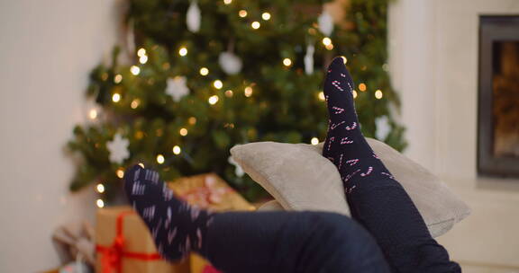 圣诞树前女人把脚放在靠垫上放松