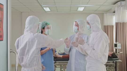 一群身着PPE套装的亚洲医生和护士在医院
