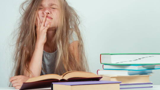 肖像疲惫悲伤的7一8岁女孩不想学习和阅读