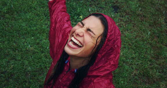 穿着雨衣享受雨水的快乐女人肖像