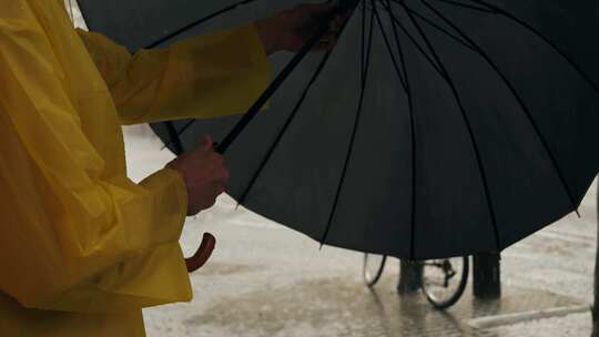 雨中欧洲城市路灯上带伞和雨衣的商人游客