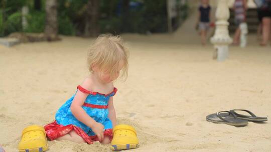 沙滩上玩沙的小女孩