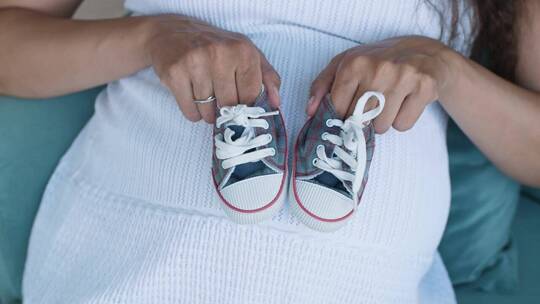 孕妇拿着小婴儿鞋_上图