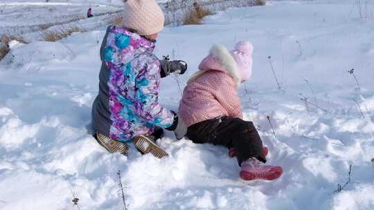 两个小姐妹躺在雪地里玩得很开心