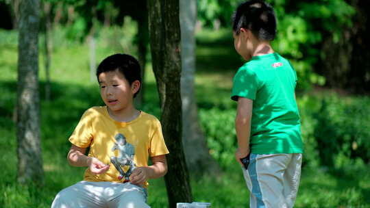 两个小孩在树林里捉虫子 玩蚱蜢 蝗虫