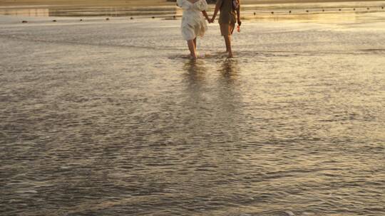 情侣牵手走在海边海水沙滩日落沙滩漫步倒影视频素材模板下载