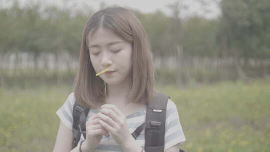 女孩漫步田间欣赏风景闻油菜花野花香灰片