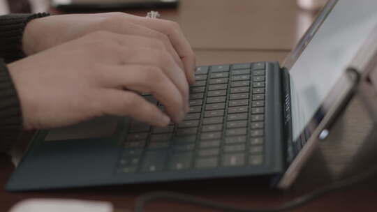 女性手在平板电脑或笔记本电脑键盘上打字