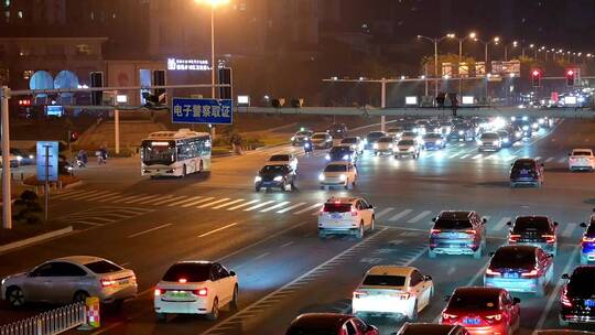 霓虹灯下的城市十字路口车流不息