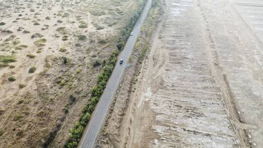 航拍行驶在沙漠公路上的汽车