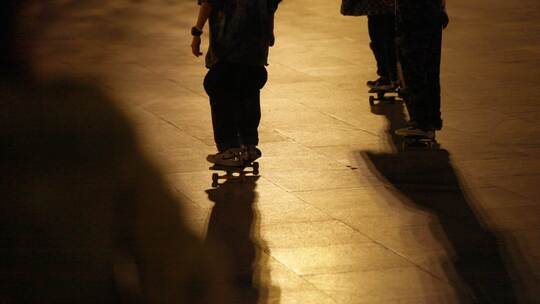 夜晚广场人群 小孩玩轮滑广场滑板