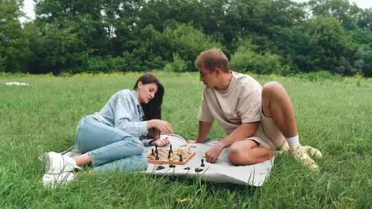 下棋一场愉快的夏季国际象棋比赛一对年轻夫